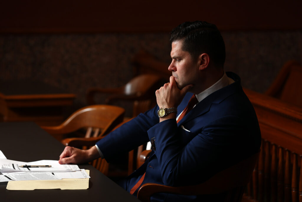 Norris Legal Group founder Graham Norris sitting in a courtroom with his hand to his chin.