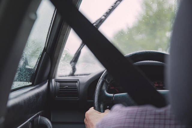 The view of someone driving a car as seen from the backseat directly behind the driver's seat.