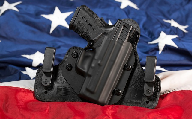 A gun in a holster with the American flag in the background.