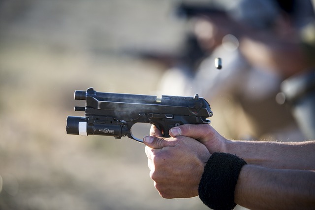 A sideways view of two hands shooting a pistol.