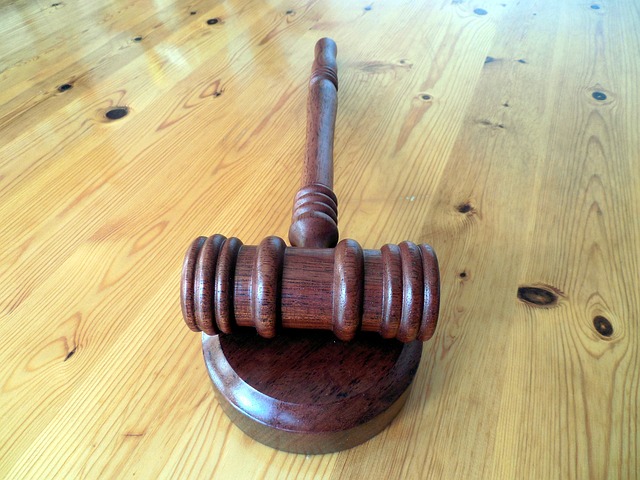 A close-up overhead view of a gavel on a wooden surface.