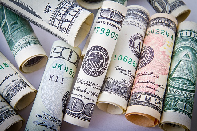 An overhead view of rolls of dollar bills in various denominations.