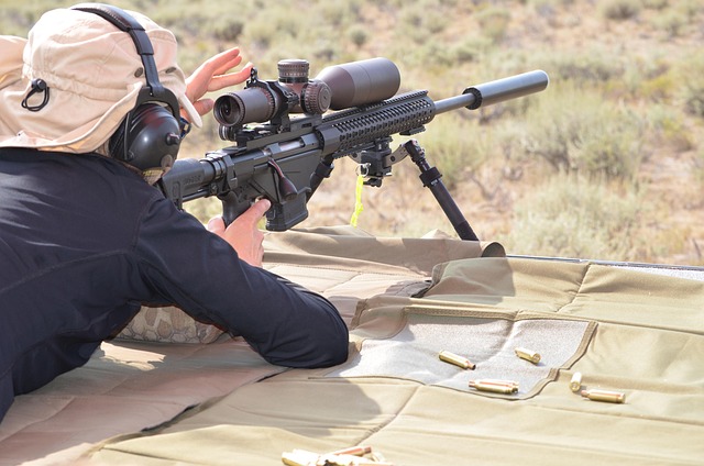 A man shooting a rifle with a scope at a shooting range.