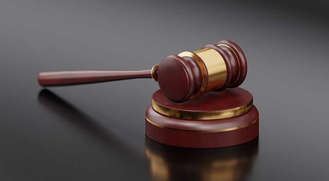 A brown gavel on a shiny dark surface.